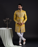 Man wearing a yellow embroidered sherwani with white pants 