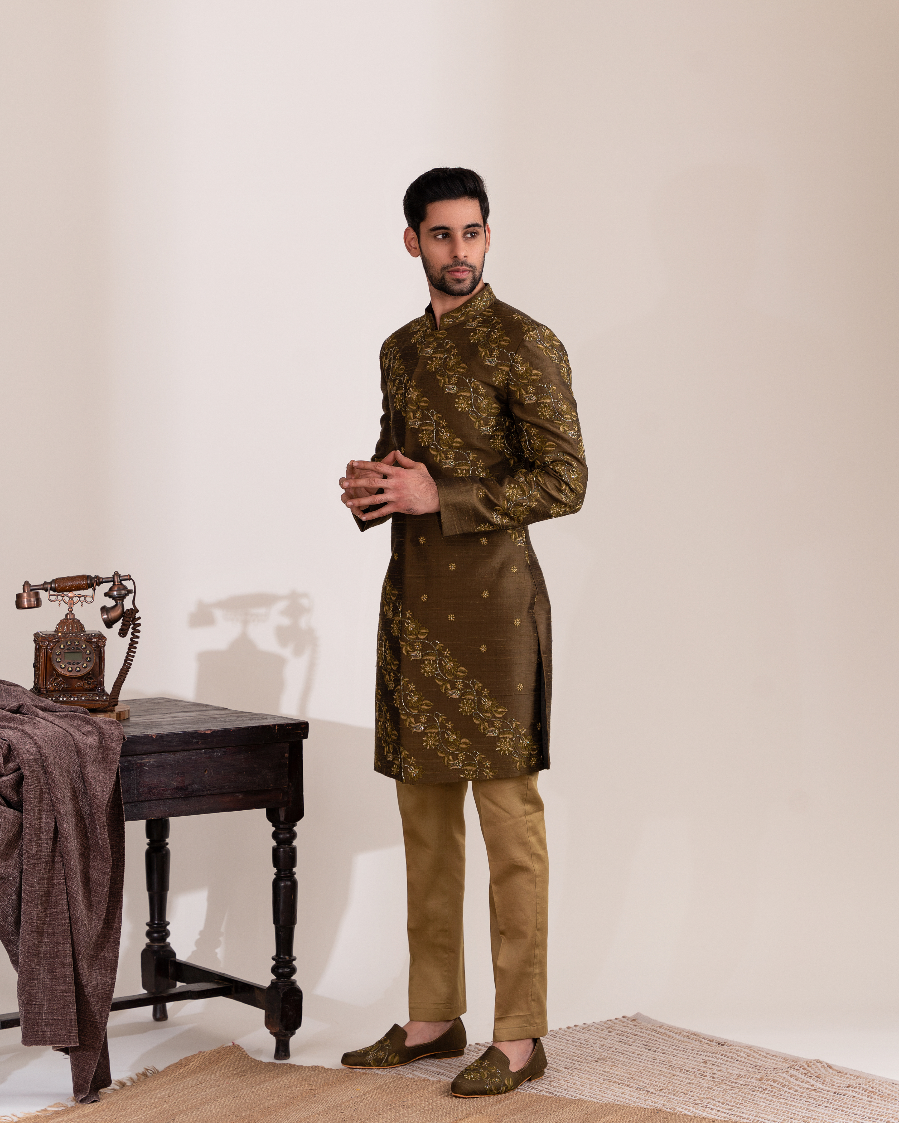 Side profile showing green sherwani structure and embroidered accents