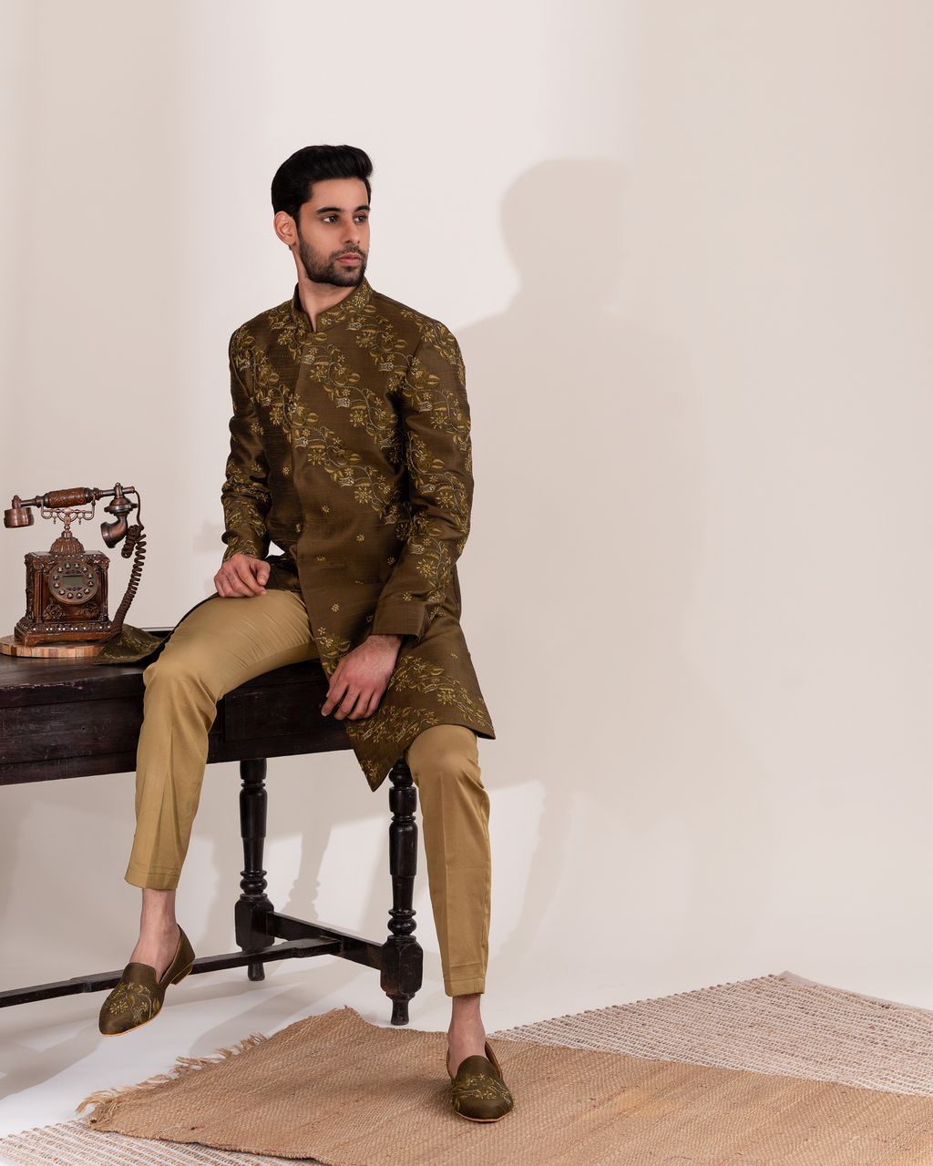 Front angle of green sherwani highlighting the botanical motifs.