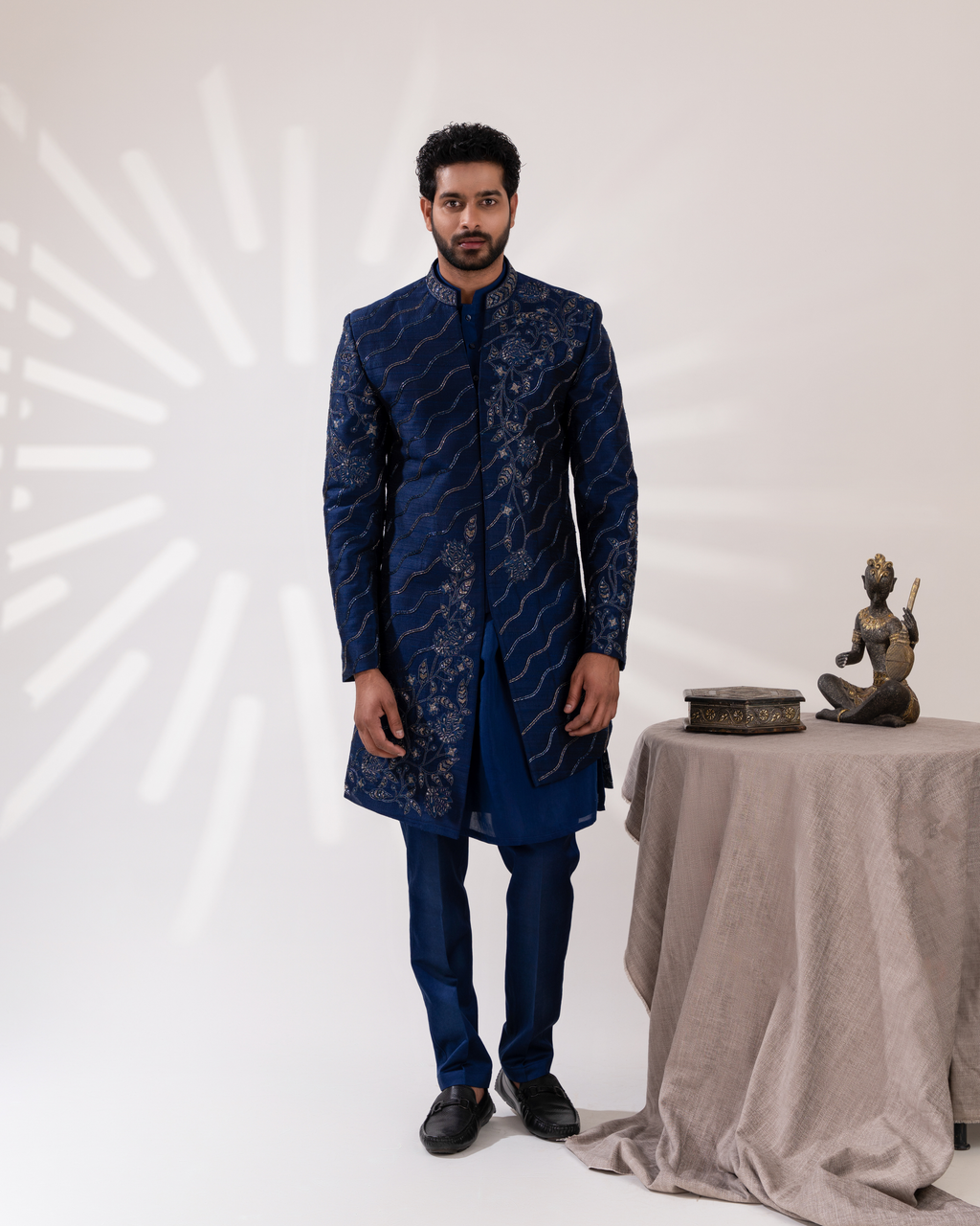 Front view of a layered navy sherwani ensemble.