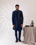 Front view of a layered navy sherwani ensemble.