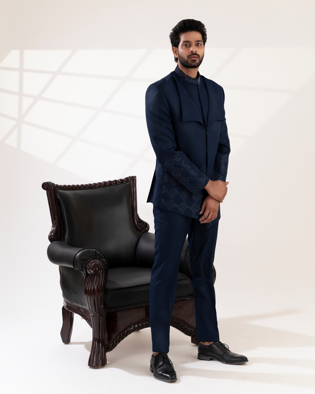 Front view of a navy bandhgala with sharp lapel detailing.