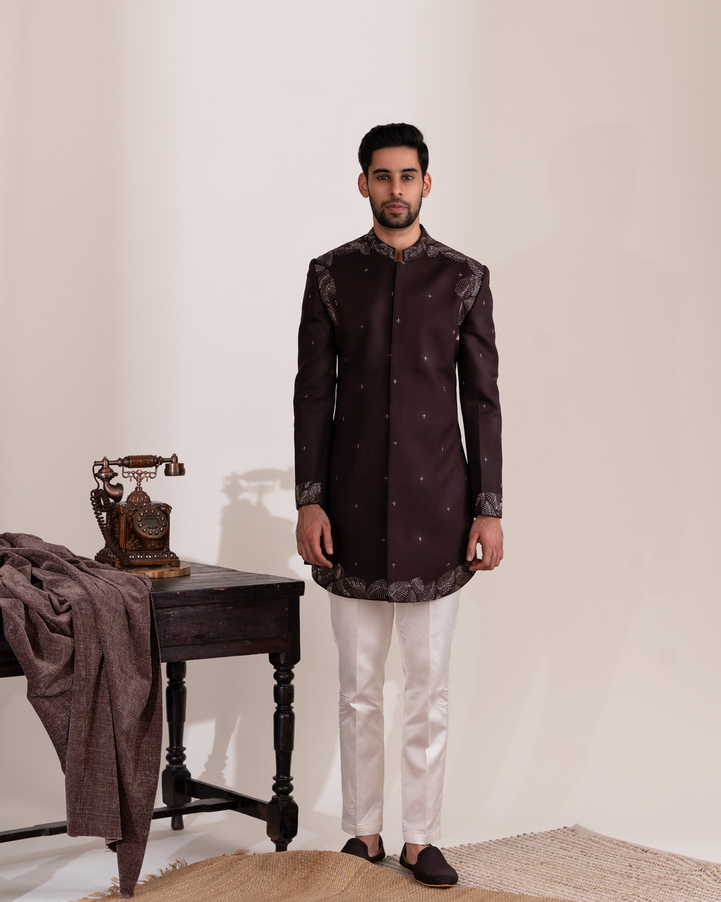 Man wearing a dark brown sherwani with white pants