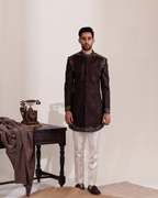 Man wearing a dark brown sherwani with white pants