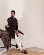 Side profile highlighting warm brown sherwani and straight white pants