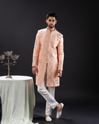 Frontal shot showing pastel peach sherwani and clean silhouette.