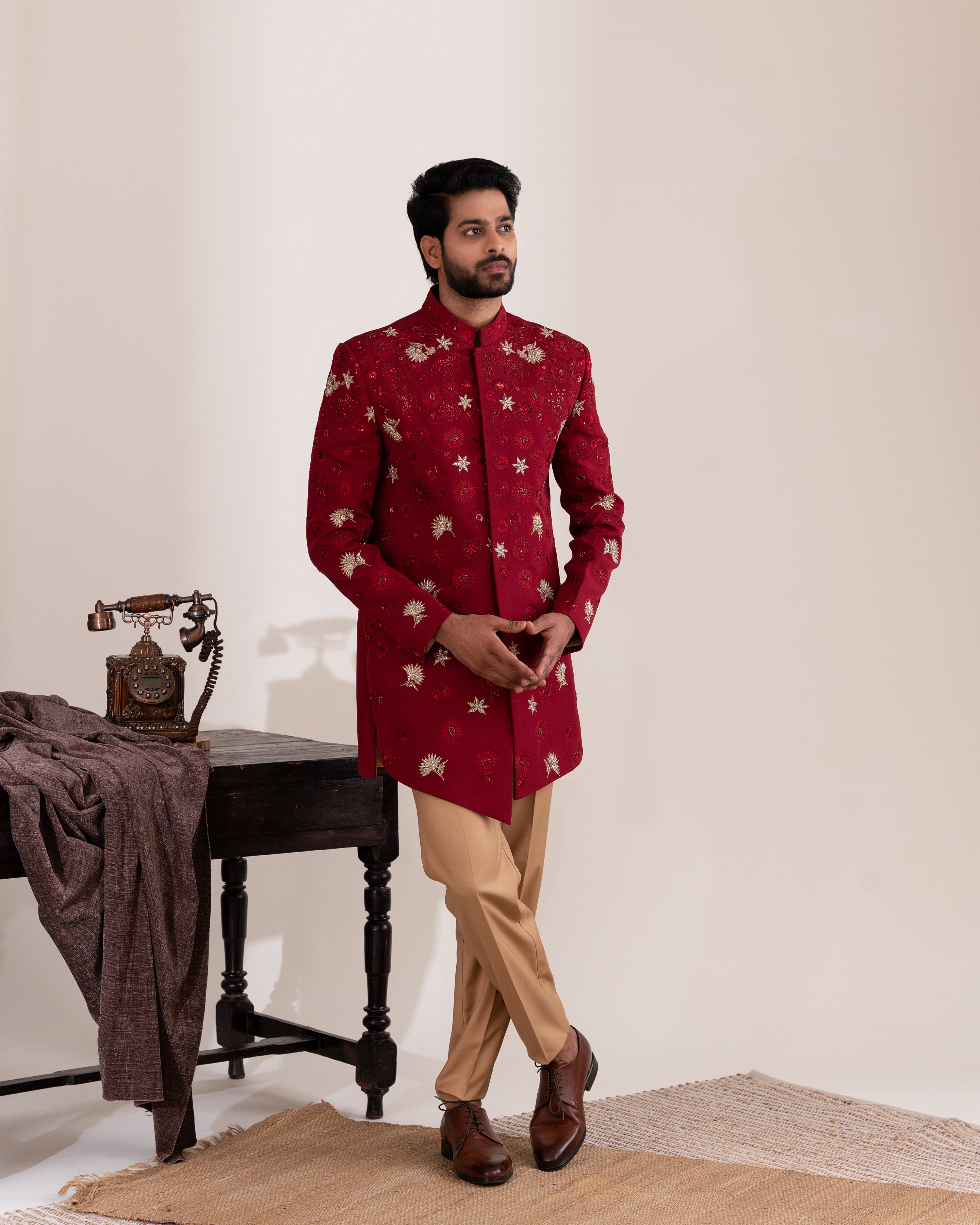 Front view of a Moroccan red Indo-western bandhgala with beige straight pants
