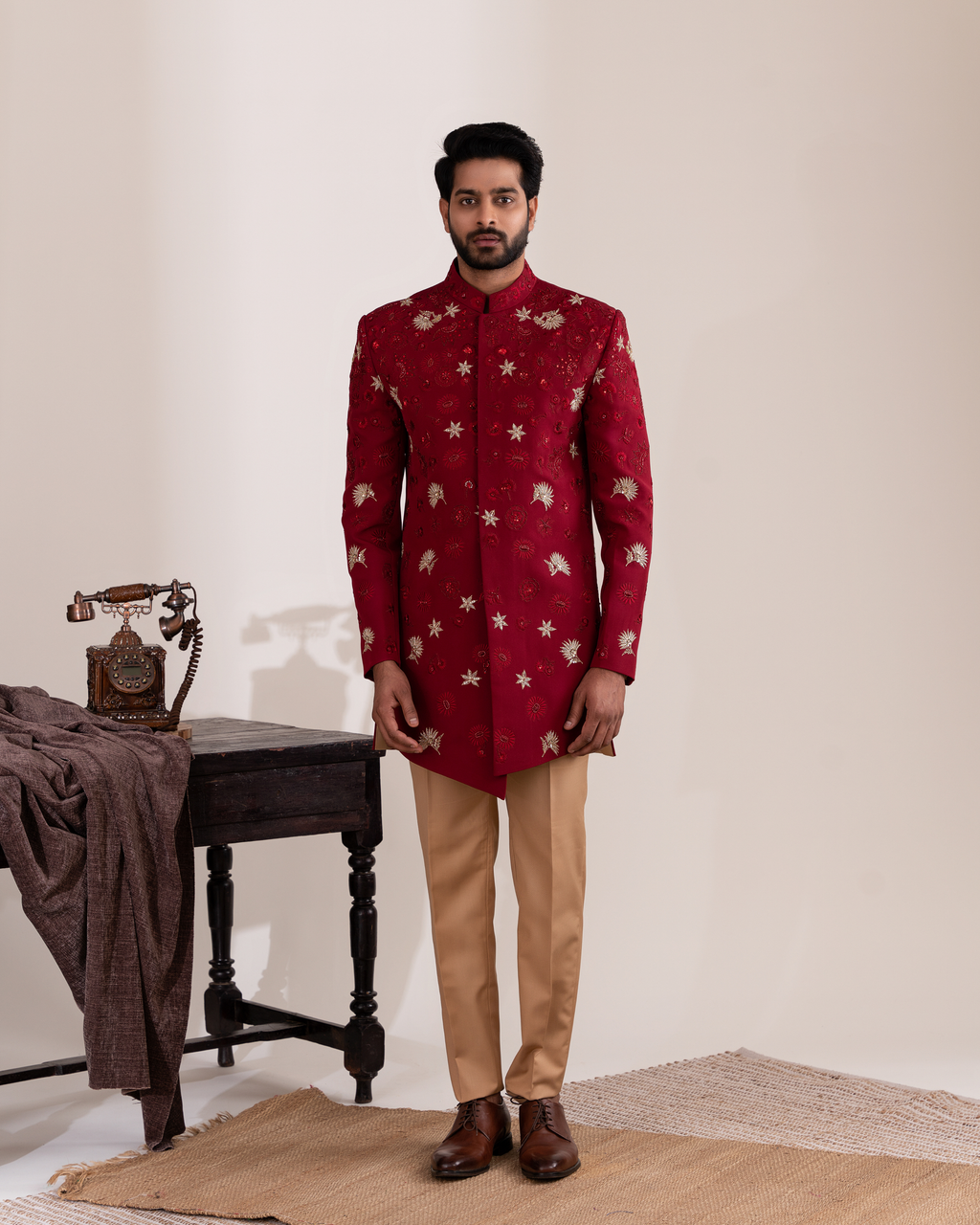 Full front view capturing the vibrant red sherwani with beige pants