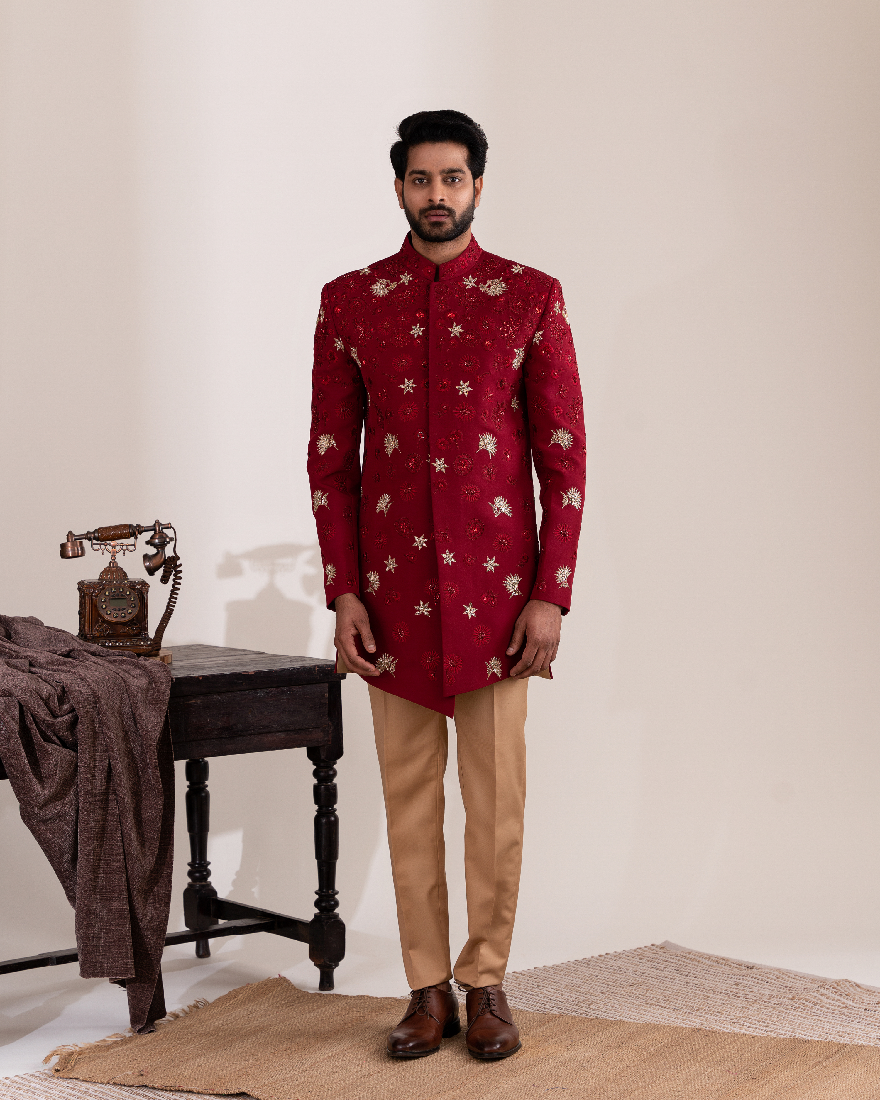 Full front view capturing the vibrant red sherwani with beige pants