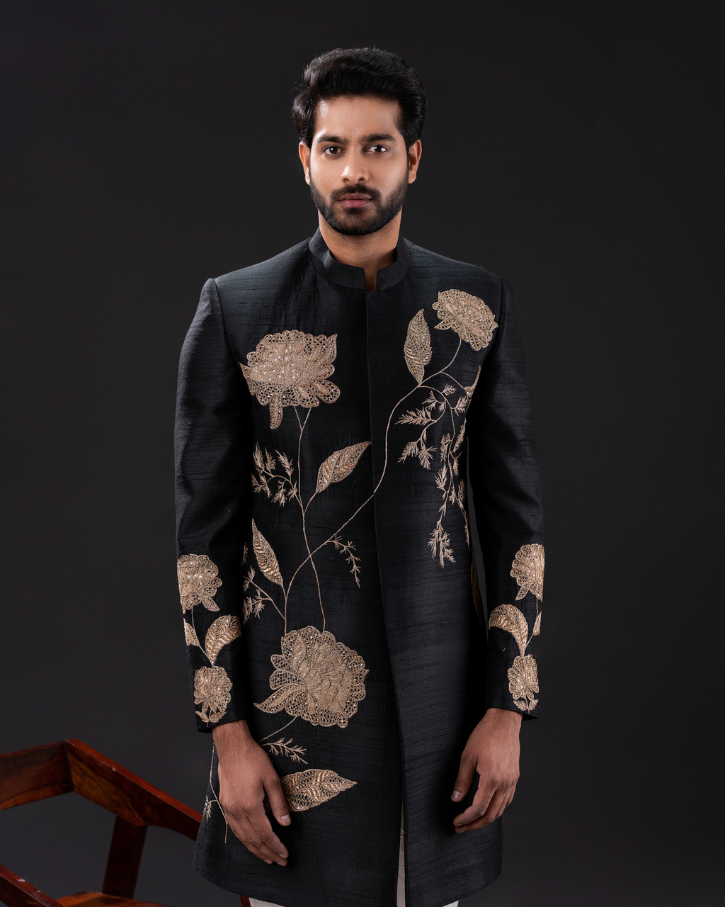 Frontal shot showcasing the gold motifs on the black sherwani