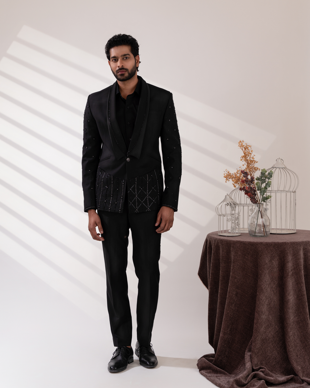 Front view of a embroidered black tuxedo and pant set.
