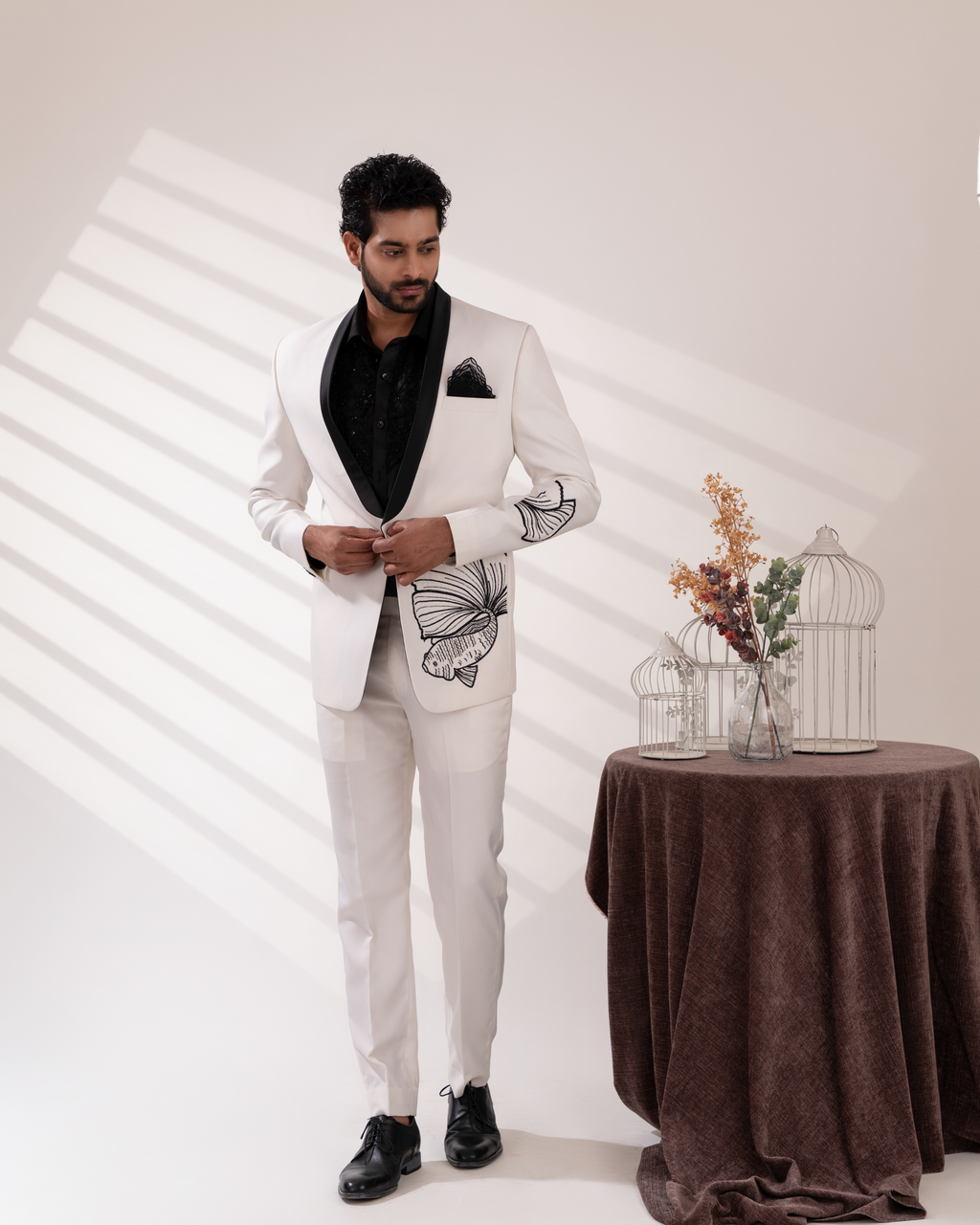 Front angle capturing fish motif embroidery on white tuxedo set