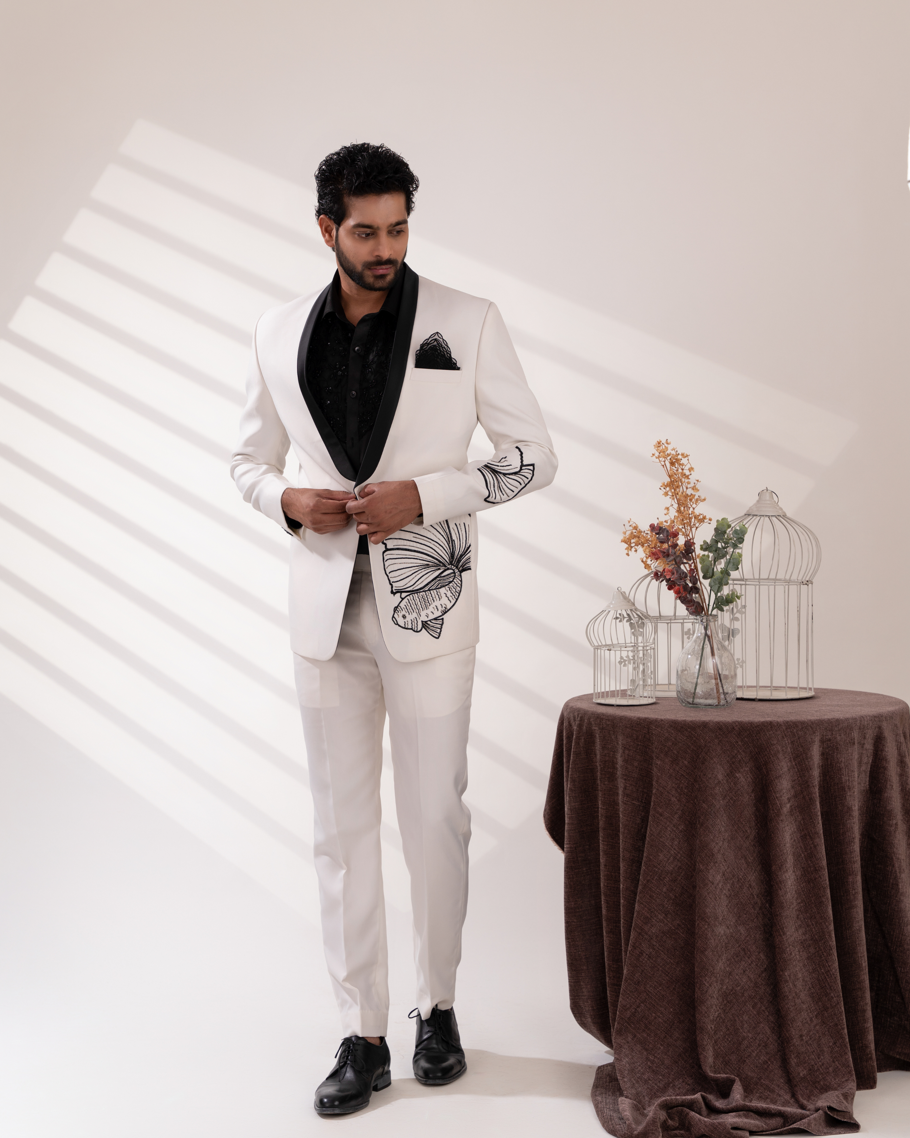 Front angle capturing fish motif embroidery on white tuxedo set