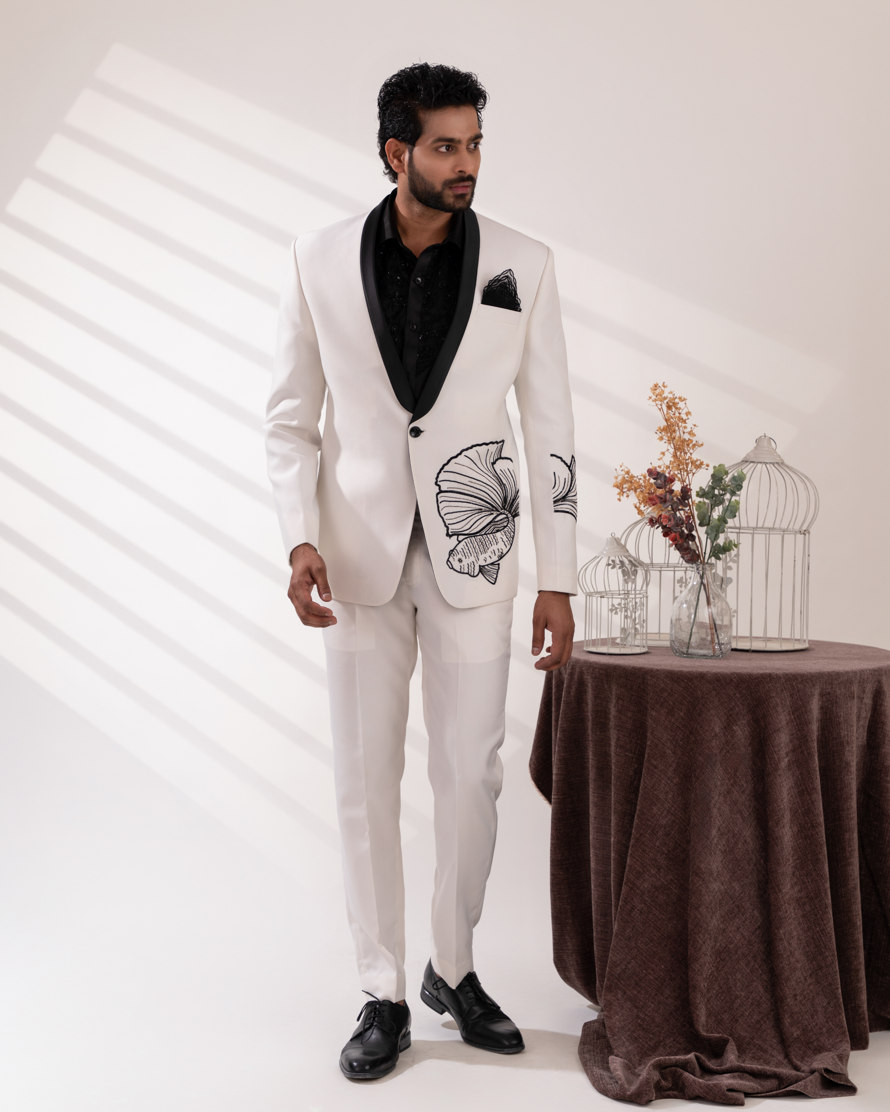 Front view of a white tuxedo set with fish motif embroidery