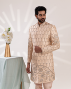 Man wearing a beige embroidered sherwani with matching pants