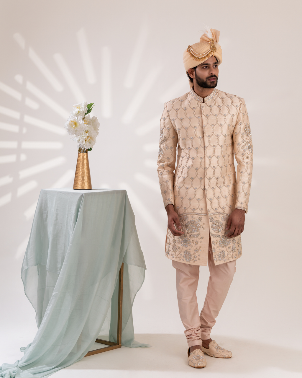 Front view of an ivory sherwani with rich hand embroidery.
