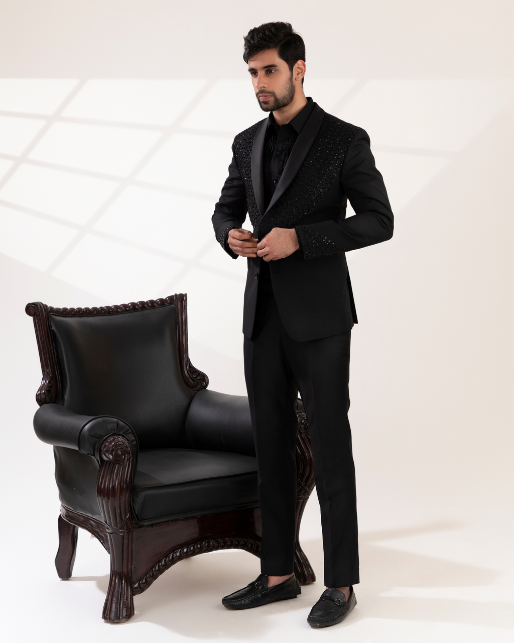 Front view of a black shawl-collar tuxedo shirt and pant set.