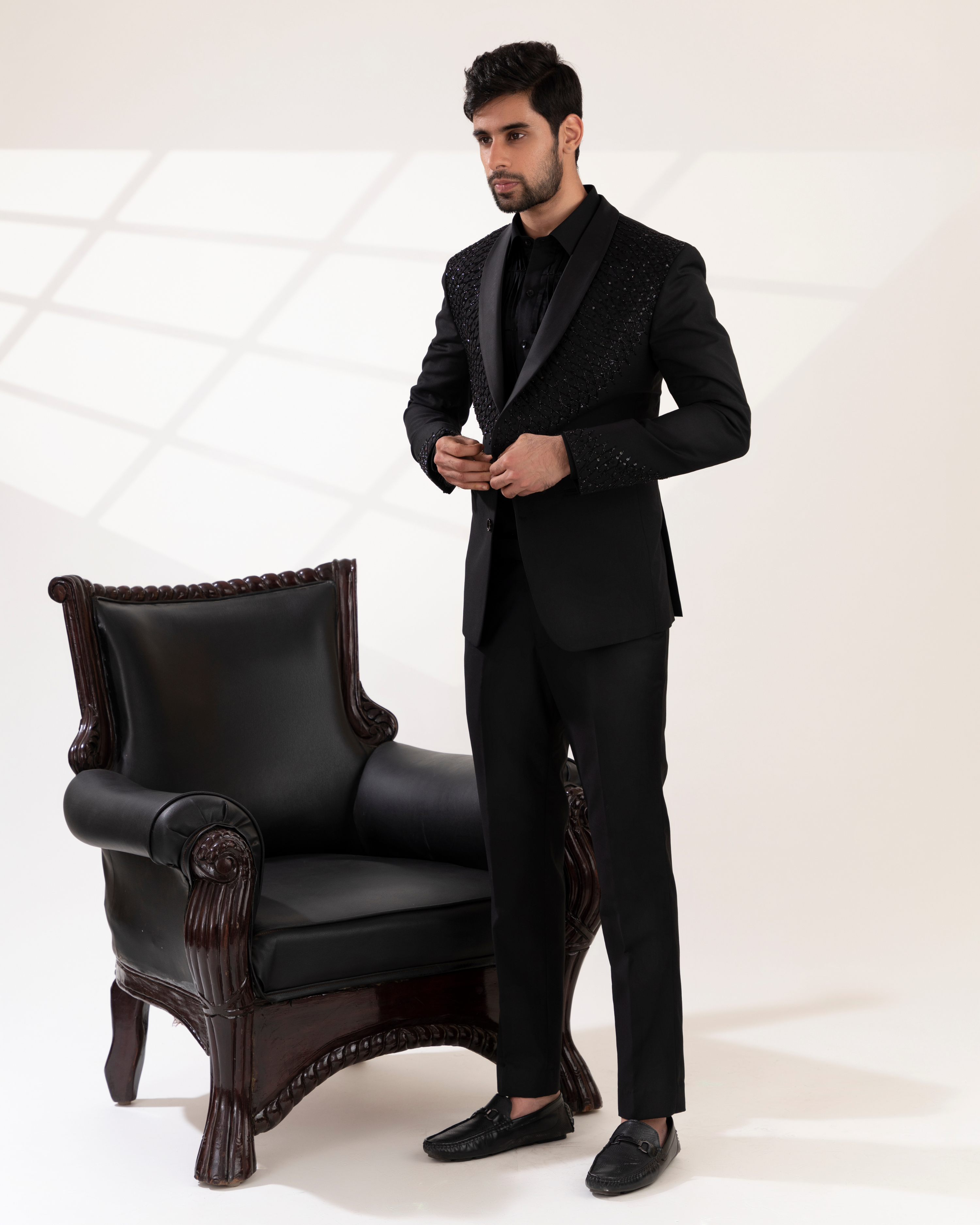 Front view of a black shawl-collar tuxedo shirt and pant set.