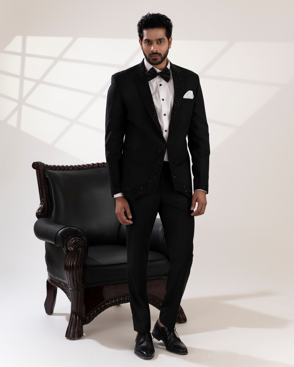 Full front view of embroidered black blazer and pant suit