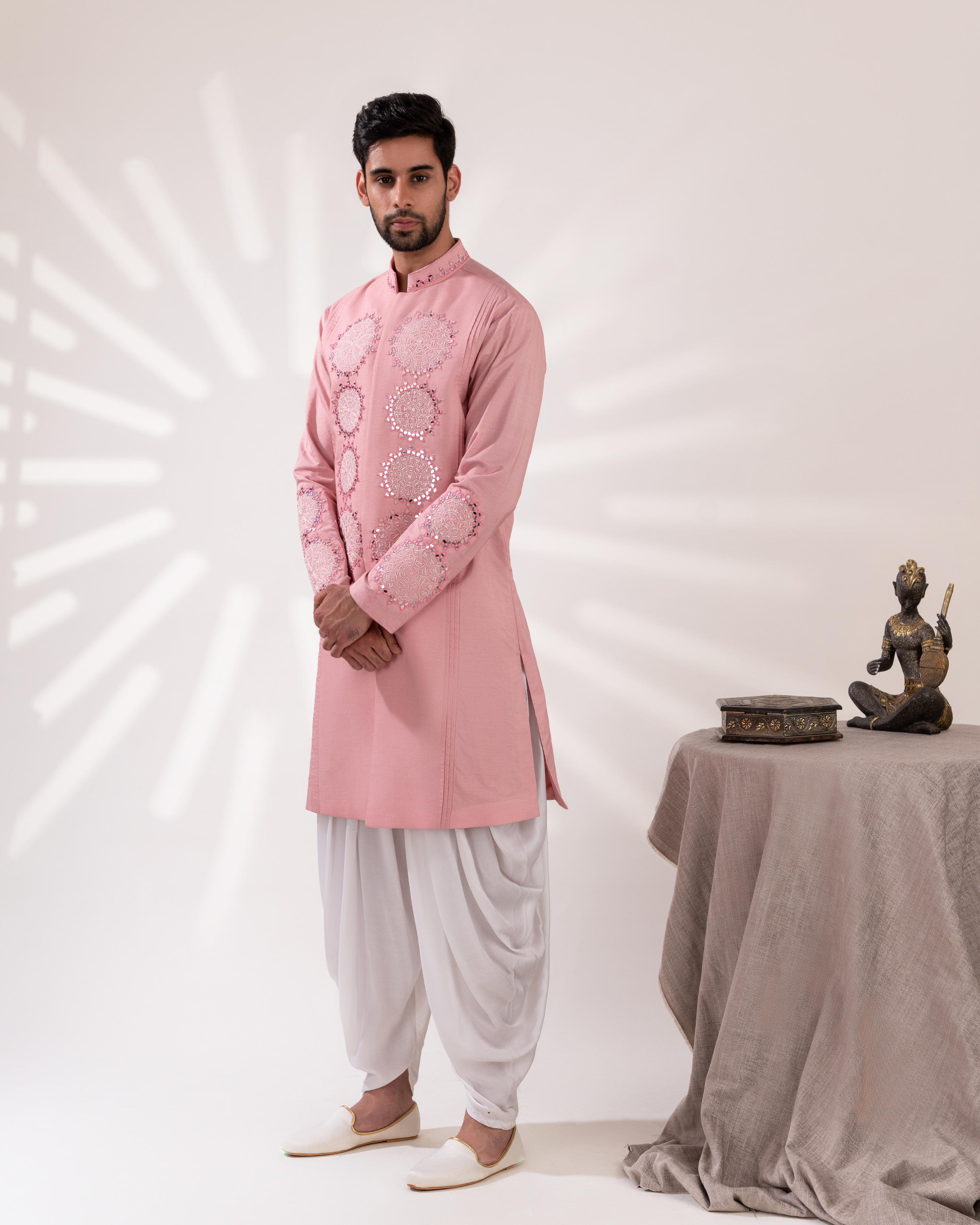 Side view capturing the sherwani structure and cowl pant movement.