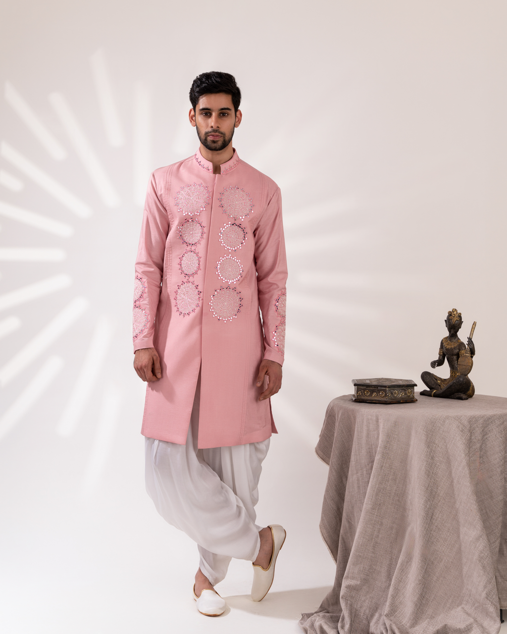 Front view of a pink sherwani paired with fluid cowl pants.