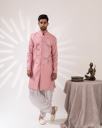 Front view of a pink sherwani paired with fluid cowl pants.