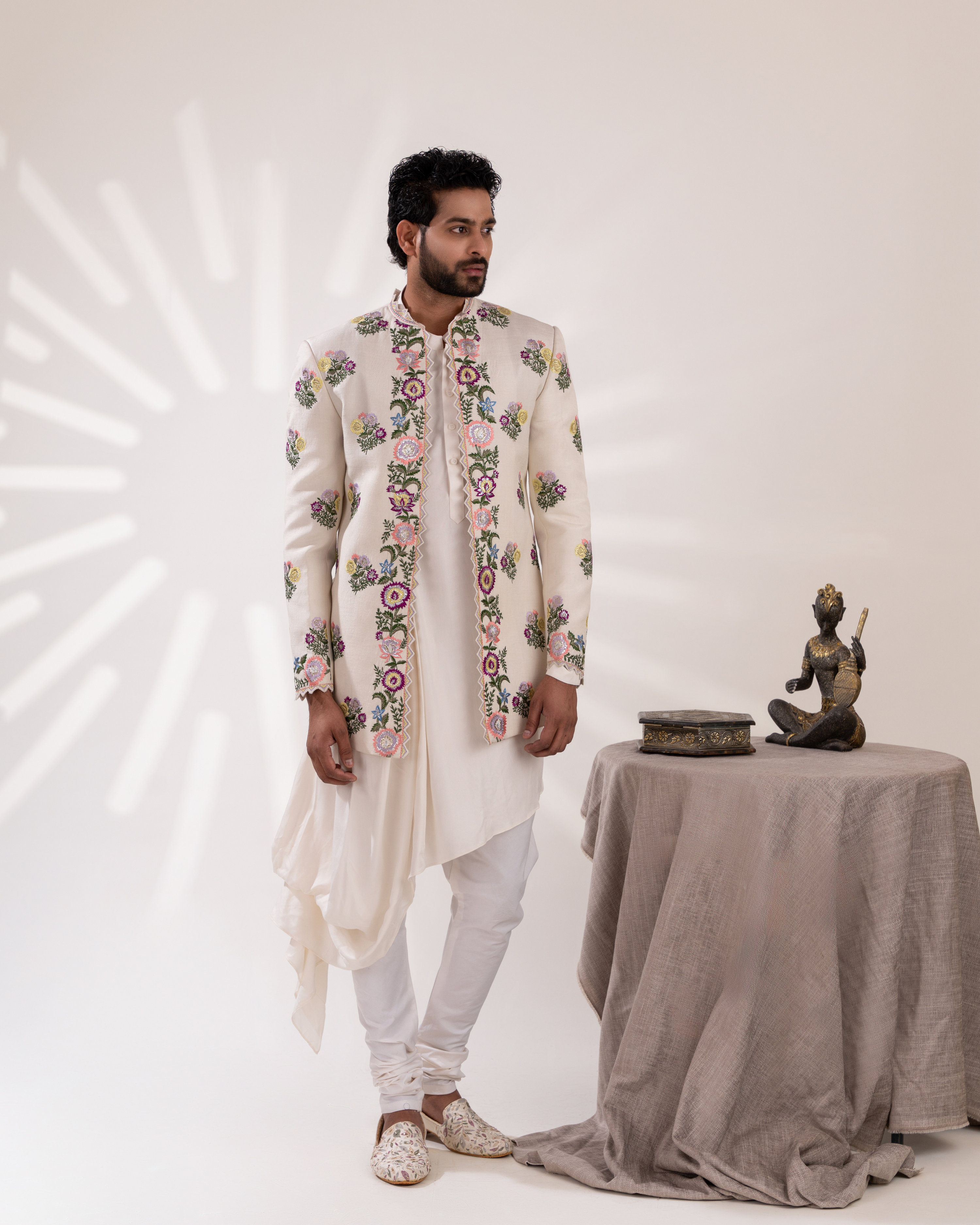 Front view of an off-white draped kurta with an embroidered jacket.