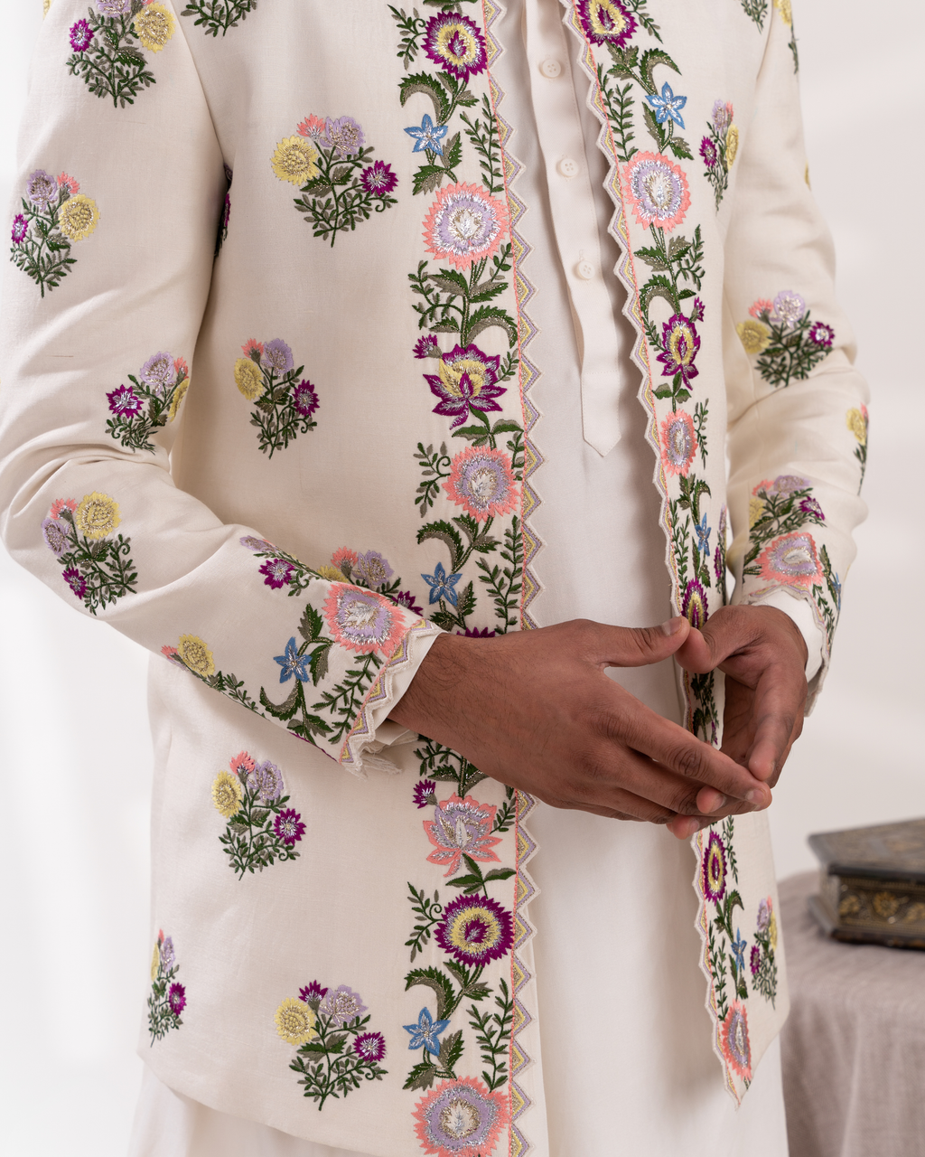 Close-up of a cream-colored sherwani with floral embroidery 