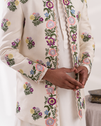 Close-up of a cream-colored sherwani with floral embroidery 