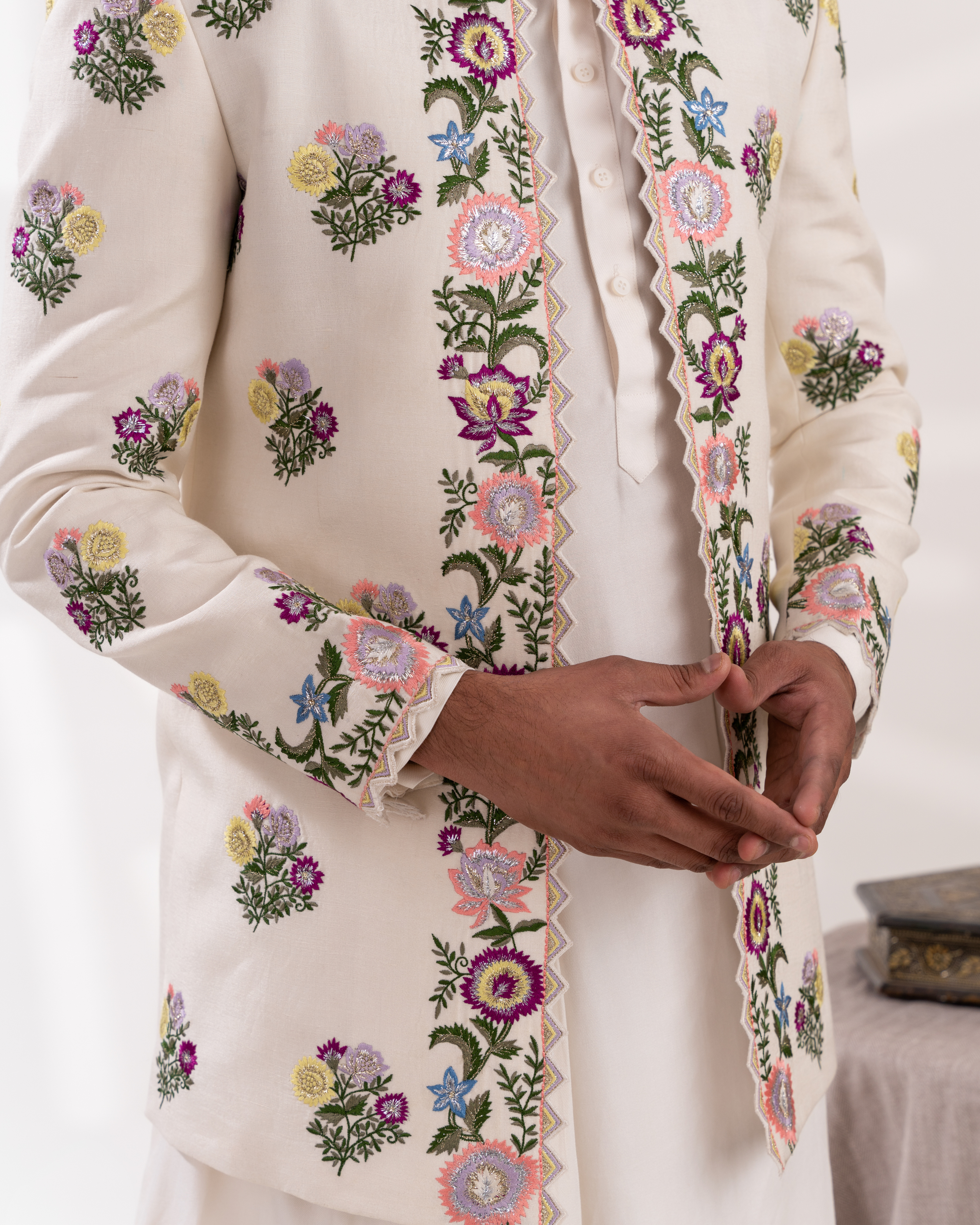 Close-up of a cream-colored sherwani with floral embroidery 