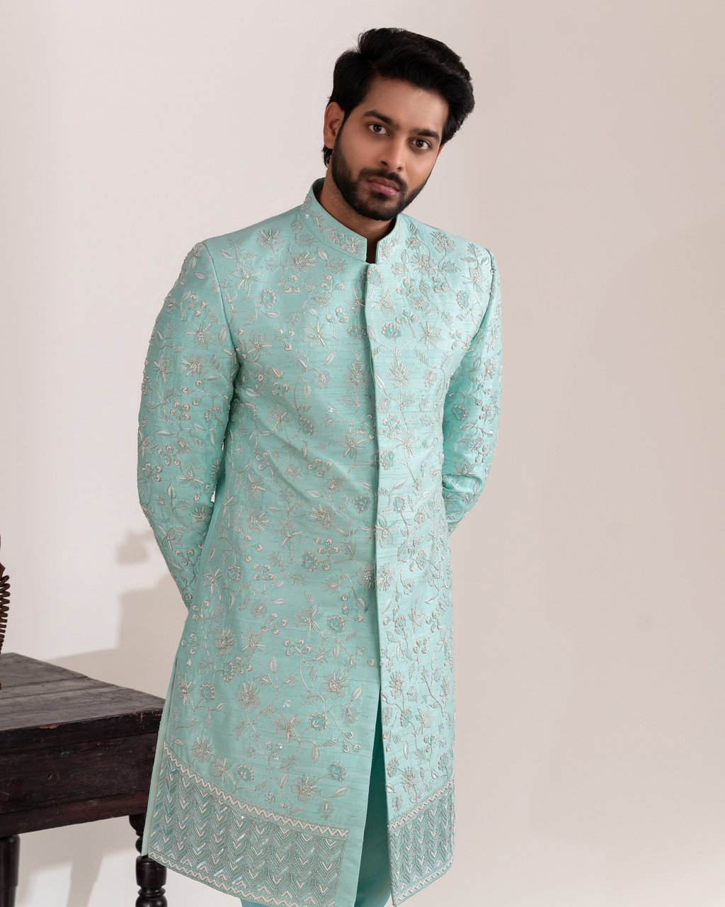 Frontal shot showing clean aqua tone and structured sherwani.
