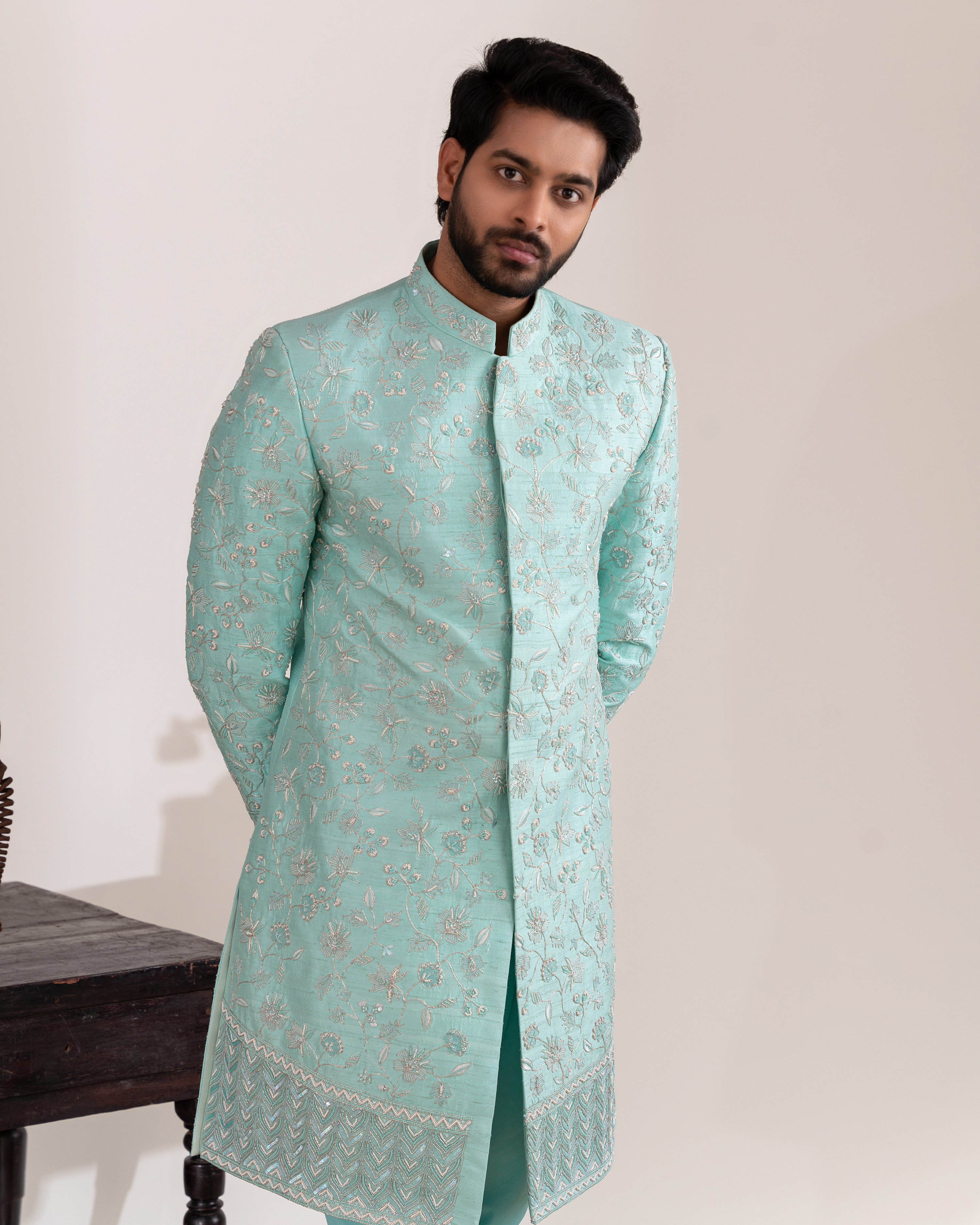 Frontal shot showing clean aqua tone and structured sherwani.