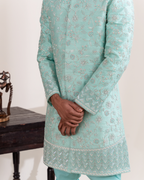 Close-up of floral embroidery on the aqua sherwani and sleeves