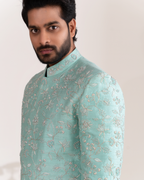 Close-up of floral embroidery on the aqua sherwani.